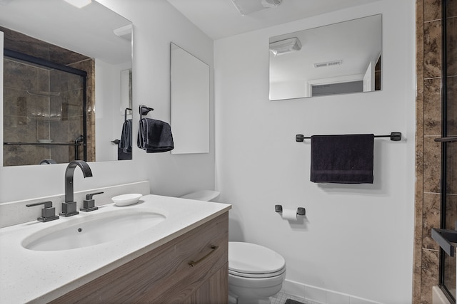 bathroom with a shower with door, vanity, and toilet