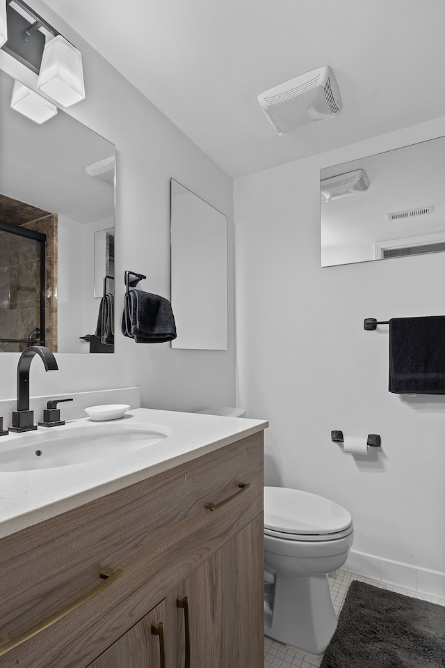 bathroom featuring toilet, vanity, and tile patterned floors