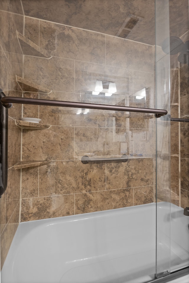 bathroom featuring shower / bath combination with glass door