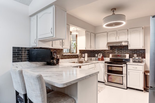 kitchen with white cabinetry, a breakfast bar area, and range with two ovens