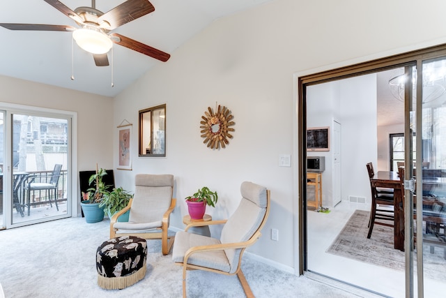 sitting room with vaulted ceiling, carpet flooring, and ceiling fan