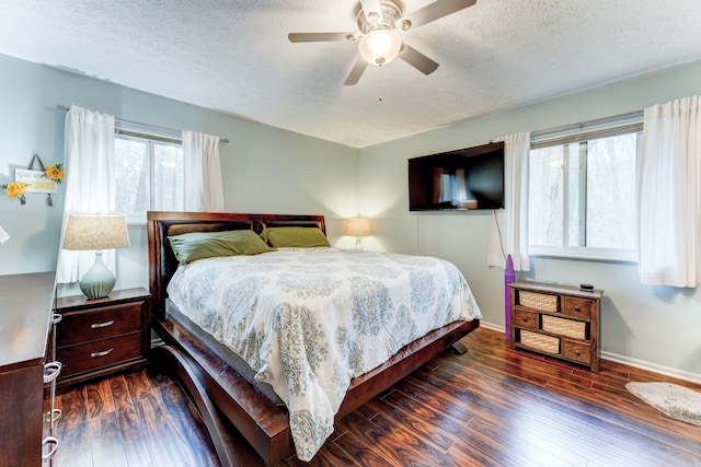 bedroom featuring ceiling fan, dark hardwood / wood-style floors, and a textured ceiling