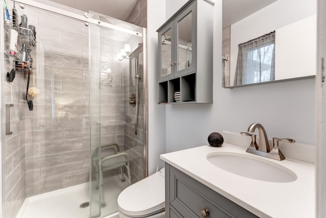 bathroom with vanity, toilet, and a shower with shower door