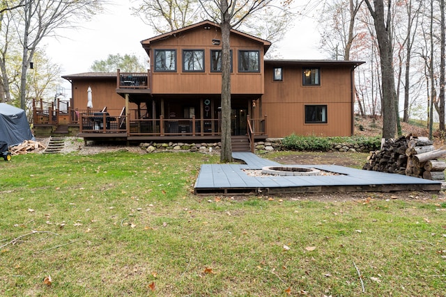 back of house featuring a wooden deck and a lawn