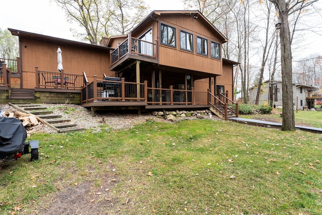 rear view of property featuring a yard and a deck