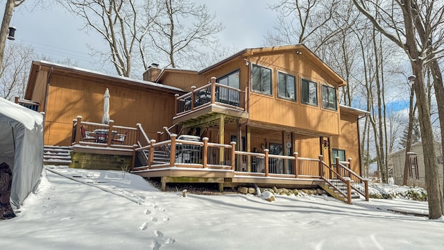 snow covered rear of property featuring a balcony