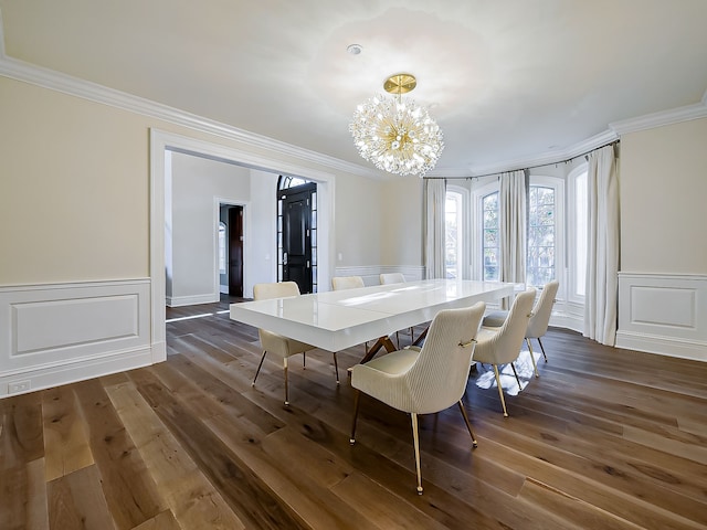 dining area featuring dark hardwood / wood-style flooring, crown molding, and a chandelier