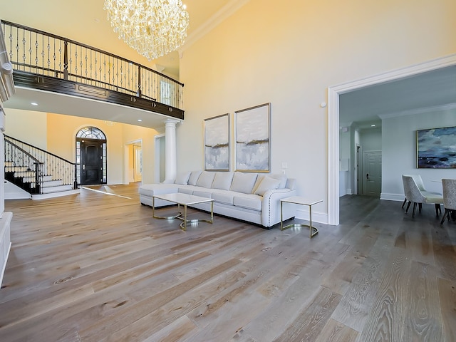 2748 Turtle Lake Dr, Bloomfield Hills, MI 48302 - living area with stairway, a high ceiling, wood finished floors, ornamental molding, and a chandelier