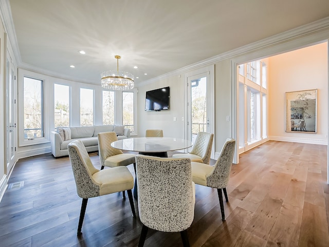 dining space with ornamental molding, a notable chandelier, and light wood-type flooring