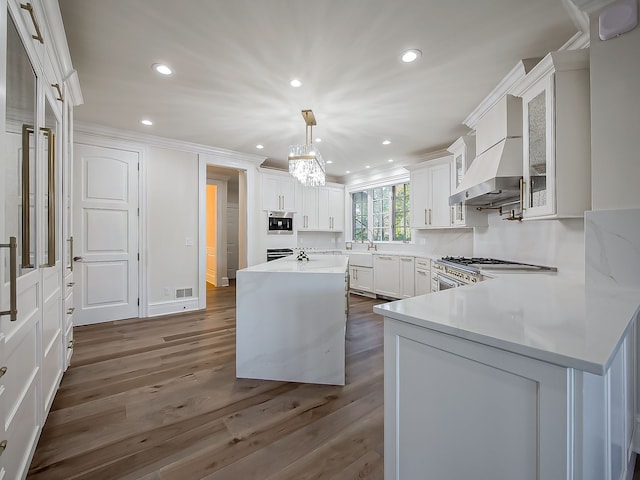 kitchen with pendant lighting, a center island, white cabinetry, and dark wood-type flooring