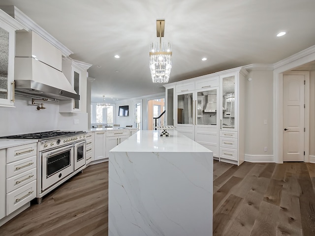 kitchen with range with two ovens, white cabinetry, dark wood-type flooring, and hanging light fixtures