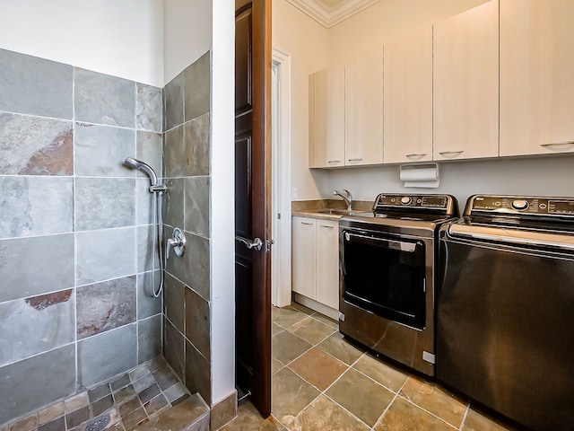 washroom featuring washer and dryer, cabinets, ornamental molding, and sink