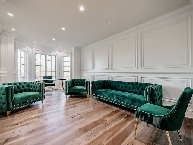 living area featuring ornamental molding and light hardwood / wood-style flooring