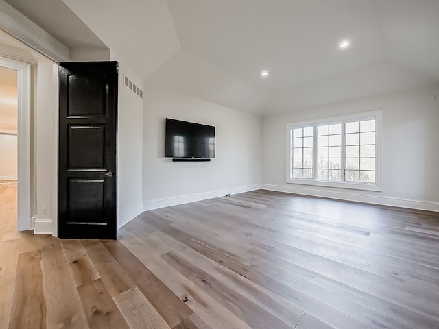 unfurnished living room with light wood-type flooring and vaulted ceiling