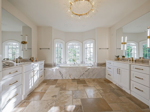 2748 Turtle Lake Dr, Bloomfield Hills, MI 48302 - full bathroom with a chandelier, stone tile floors, two vanities, and a bath