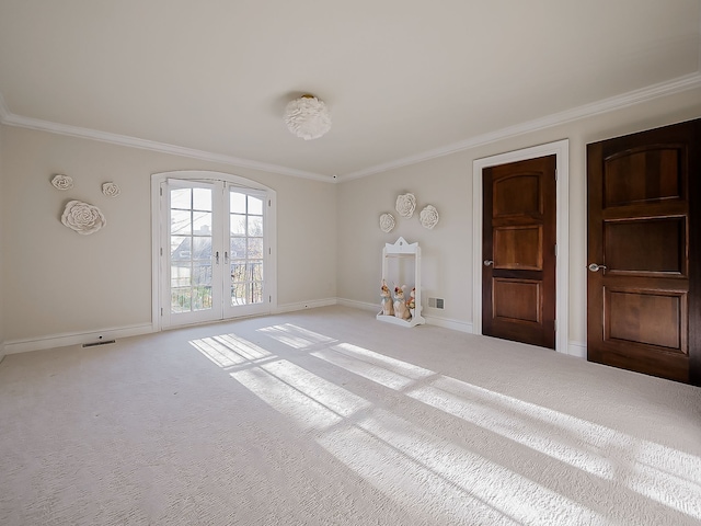 empty room featuring light colored carpet, ornamental molding, and french doors