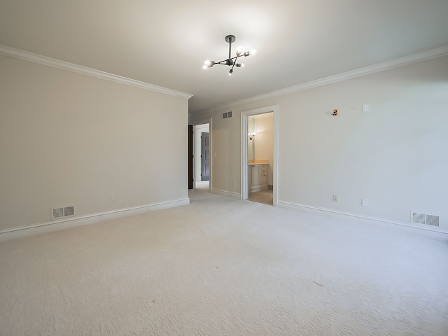 carpeted empty room featuring an inviting chandelier and ornamental molding