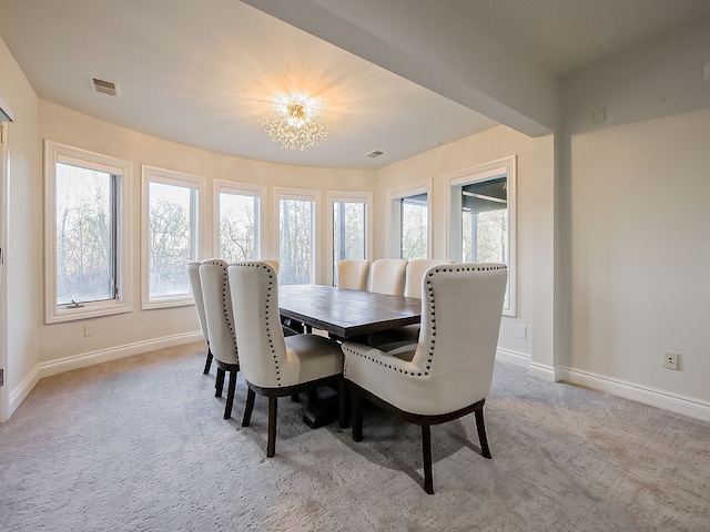 dining space featuring a notable chandelier and light colored carpet