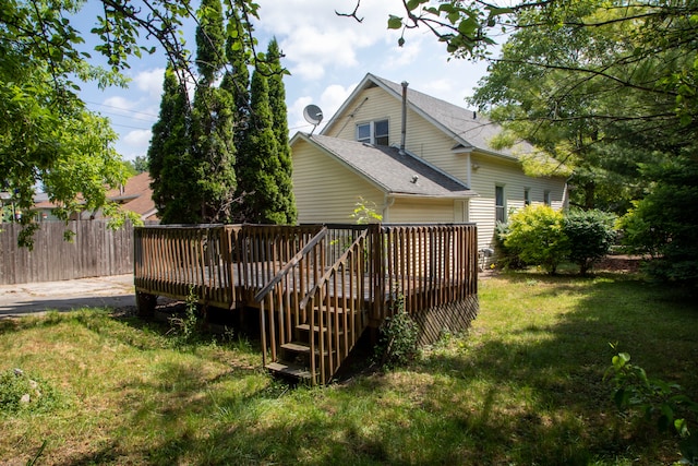 rear view of property with a lawn and a wooden deck