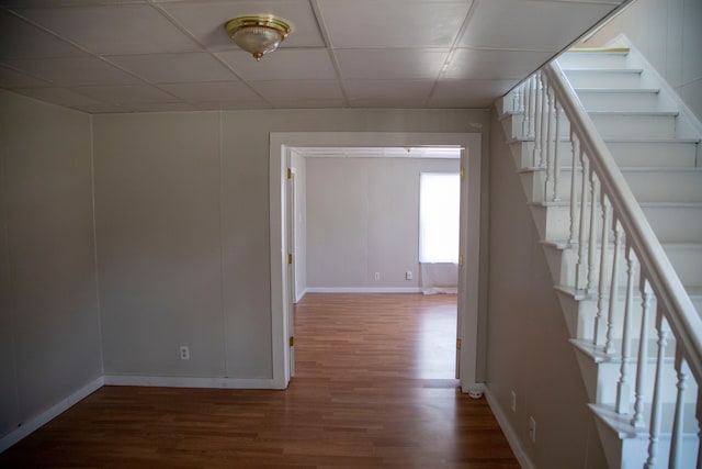 interior space featuring a drop ceiling and wood-type flooring