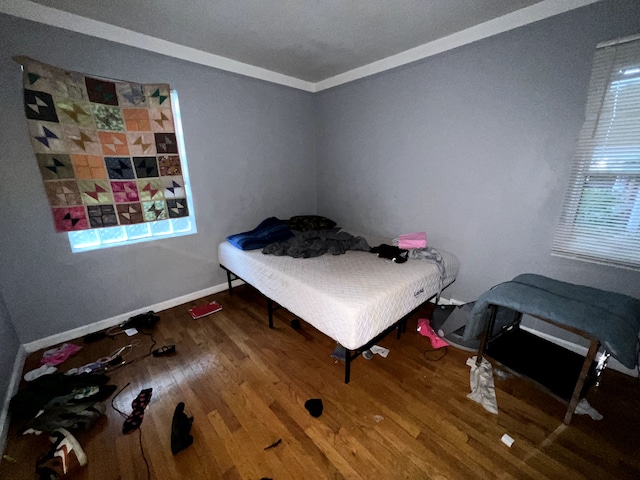 bedroom featuring crown molding and wood-type flooring