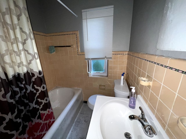 full bathroom with shower / bath combo, sink, tile patterned flooring, toilet, and tile walls