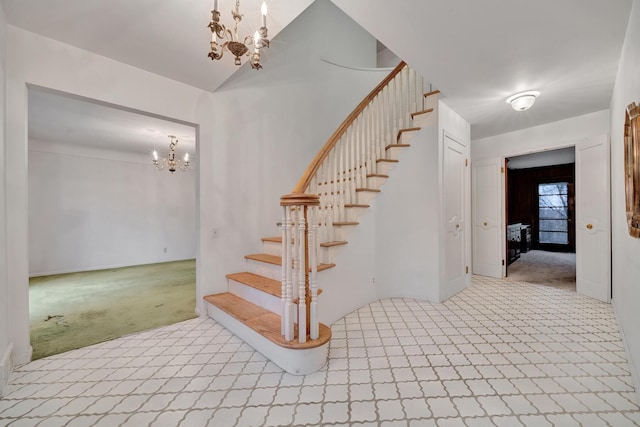 stairs with a notable chandelier and carpet floors