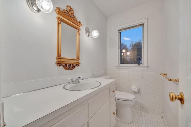 bathroom featuring tile patterned flooring, vanity, tile walls, and toilet