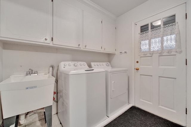 laundry room featuring cabinets, sink, and washing machine and clothes dryer