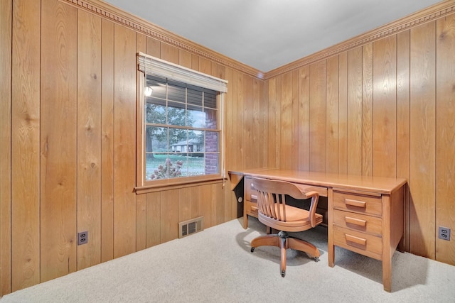 carpeted home office featuring built in desk, ornamental molding, and wooden walls