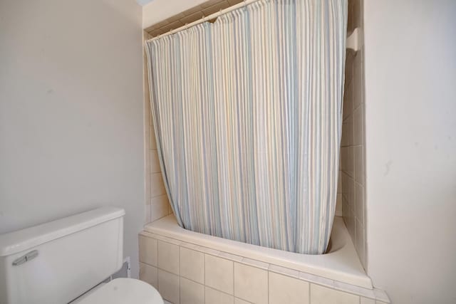 bathroom featuring shower / bath combination with curtain and toilet