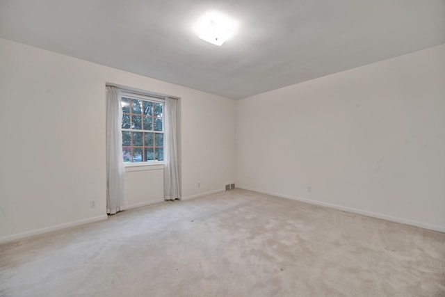 spare room featuring light colored carpet