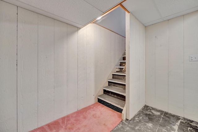 basement featuring wood walls