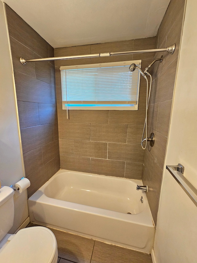 bathroom with tiled shower / bath combo and toilet