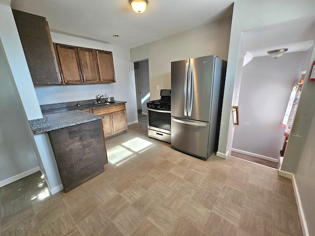 kitchen with sink, dark stone counters, and appliances with stainless steel finishes