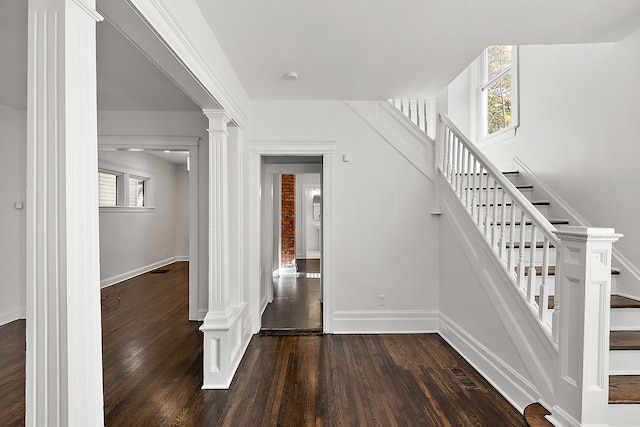 stairway featuring ornate columns and hardwood / wood-style floors