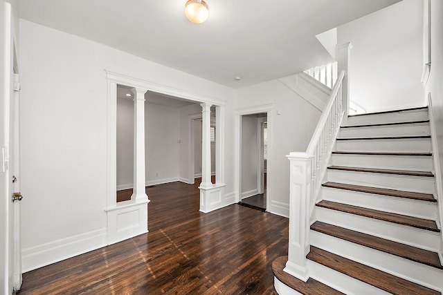 foyer featuring dark hardwood / wood-style floors and ornate columns