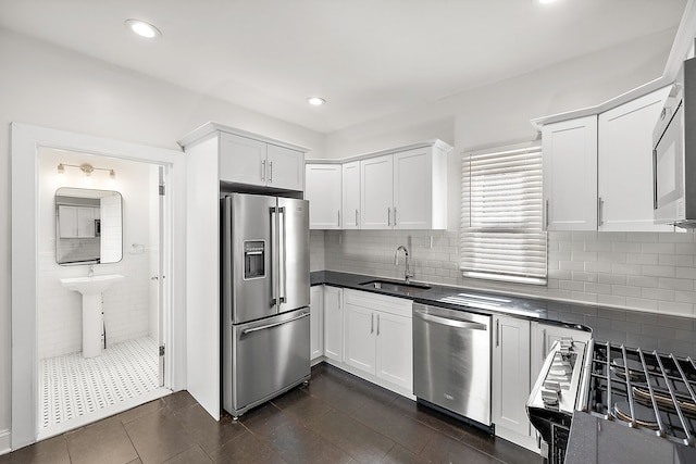 kitchen with white cabinets, appliances with stainless steel finishes, decorative backsplash, and sink