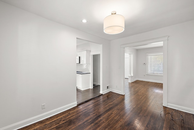 spare room featuring dark wood-type flooring