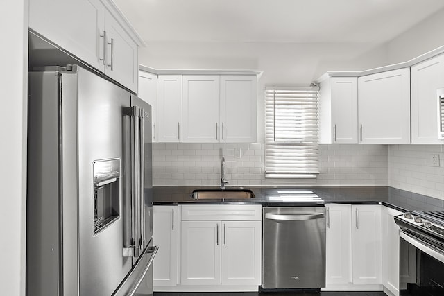 kitchen featuring decorative backsplash, white cabinetry, sink, and appliances with stainless steel finishes