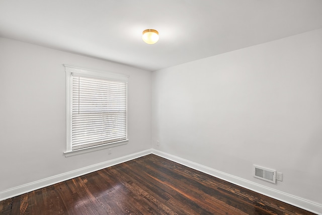 spare room with dark wood-type flooring