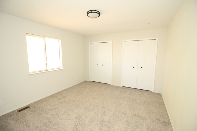 40831 Highpointe Dr, Clinton Township, MI 48038 - unfurnished bedroom featuring multiple closets, light colored carpet, and baseboards