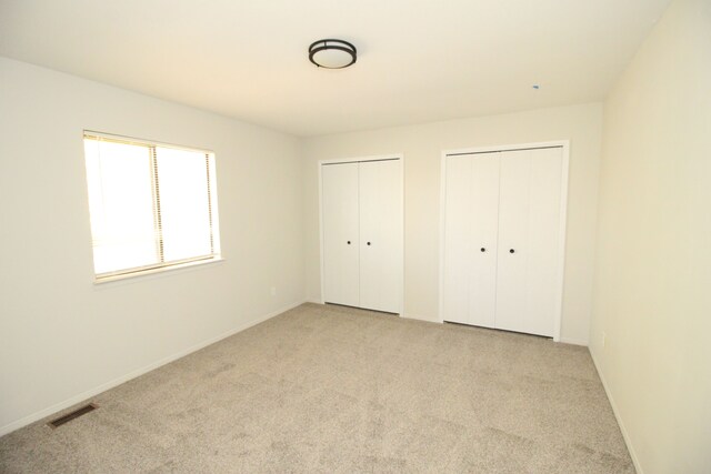 40831 Highpointe Dr, Clinton Township, MI 48038 - unfurnished bedroom with two closets, light colored carpet, and baseboards