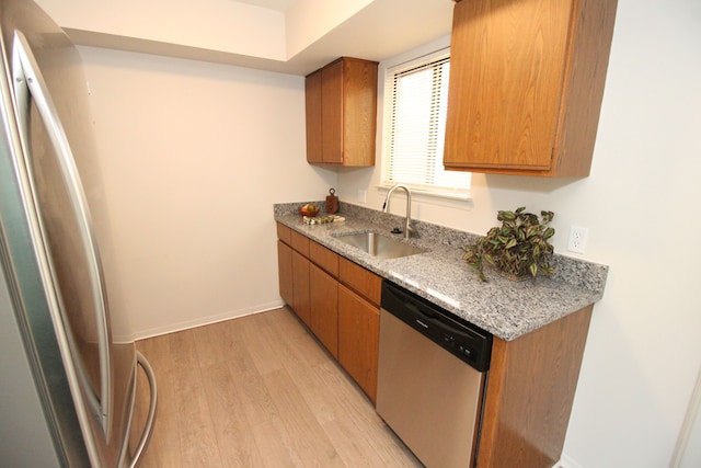 40831 Highpointe Dr, Clinton Township, MI 48038 - kitchen featuring appliances with stainless steel finishes, a sink, light wood-style floors, baseboards, and brown cabinets
