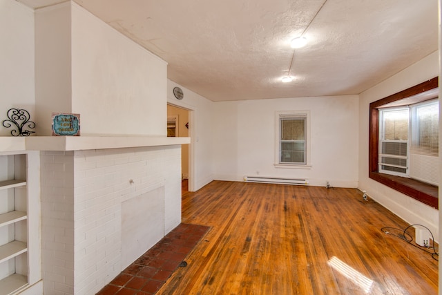 unfurnished living room with a brick fireplace, a textured ceiling, hardwood / wood-style flooring, and a baseboard radiator