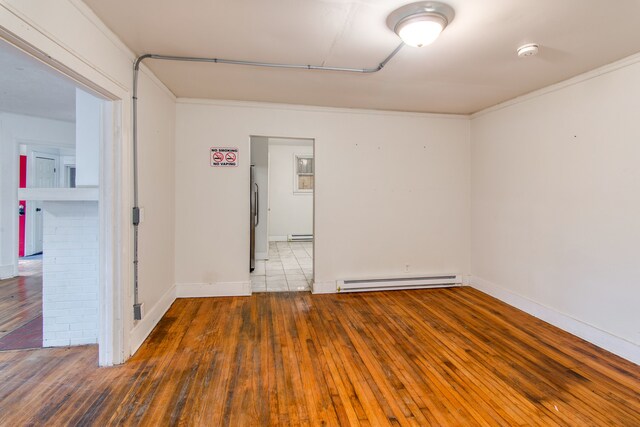 unfurnished room with dark wood-type flooring, a baseboard radiator, and ornamental molding