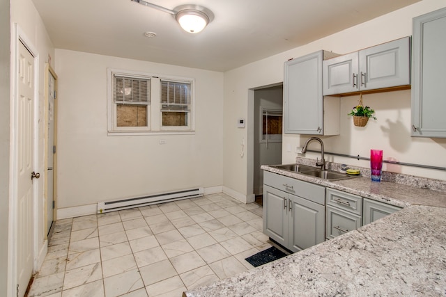 kitchen featuring gray cabinetry, light stone counters, sink, and a baseboard radiator