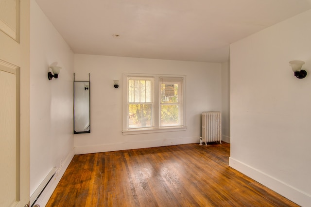 spare room with dark hardwood / wood-style flooring, radiator, and a baseboard heating unit