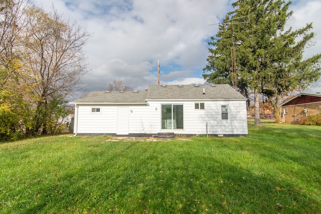 rear view of house featuring a lawn