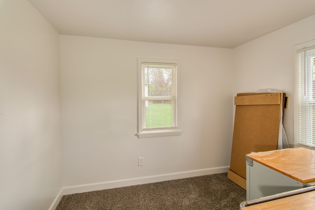 unfurnished bedroom with dark carpet